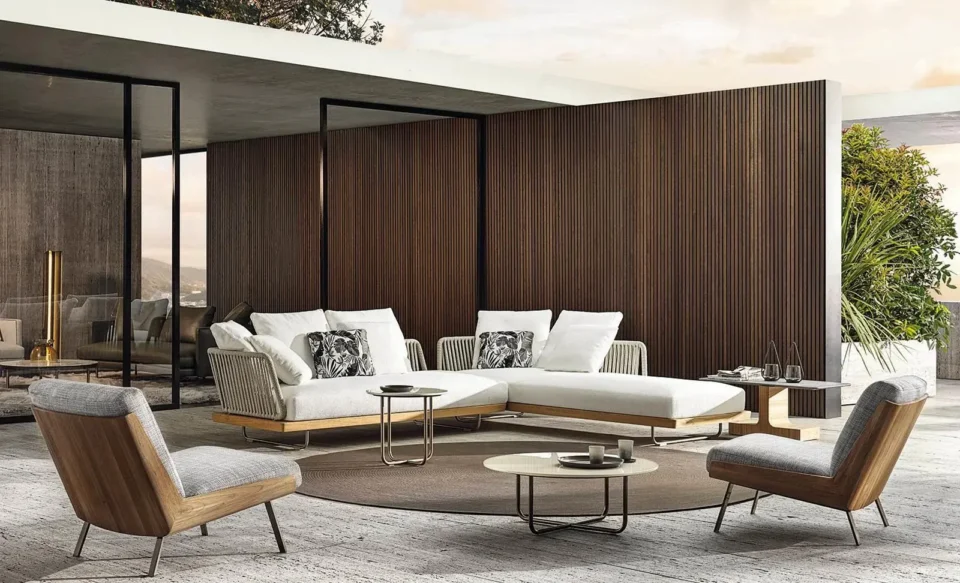A luxury outdoor space consisting of a sofa, table and two chairs.